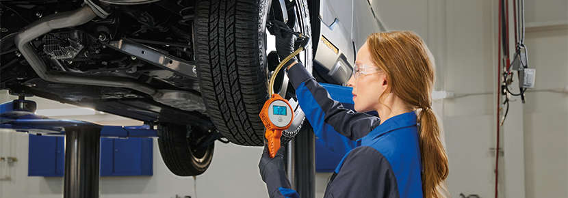 A Subaru technician checking tire pressure. | Subaru of Ann Arbor in Ann Arbor MI