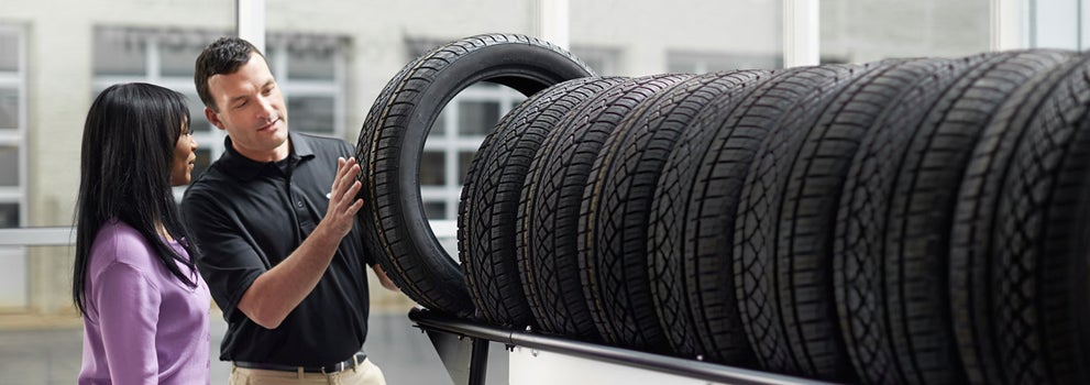 Subaru service representative showing customer a tire. | Subaru of Ann Arbor in Ann Arbor MI