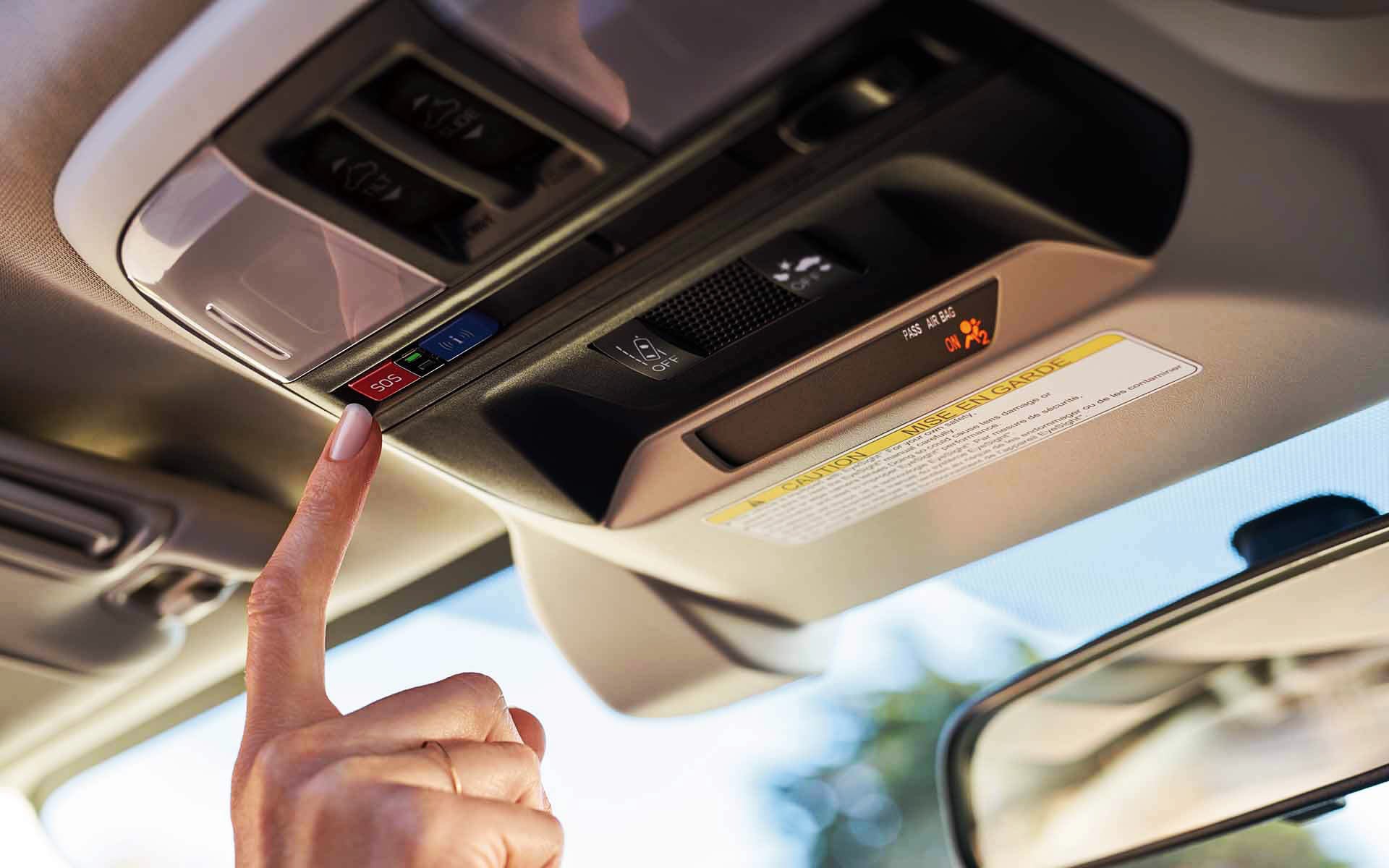 A finger pressing the Crosstrek Hybrid's SOS emergency assistance button | Subaru of Ann Arbor in Ann Arbor MI
