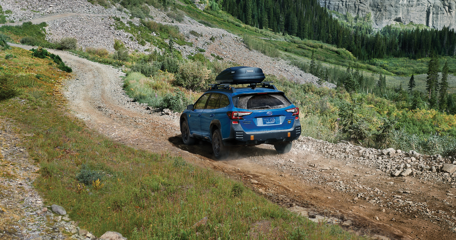 A 2023 Outback Wilderness driving on a trail in the mountains. | Subaru of Ann Arbor in Ann Arbor MI